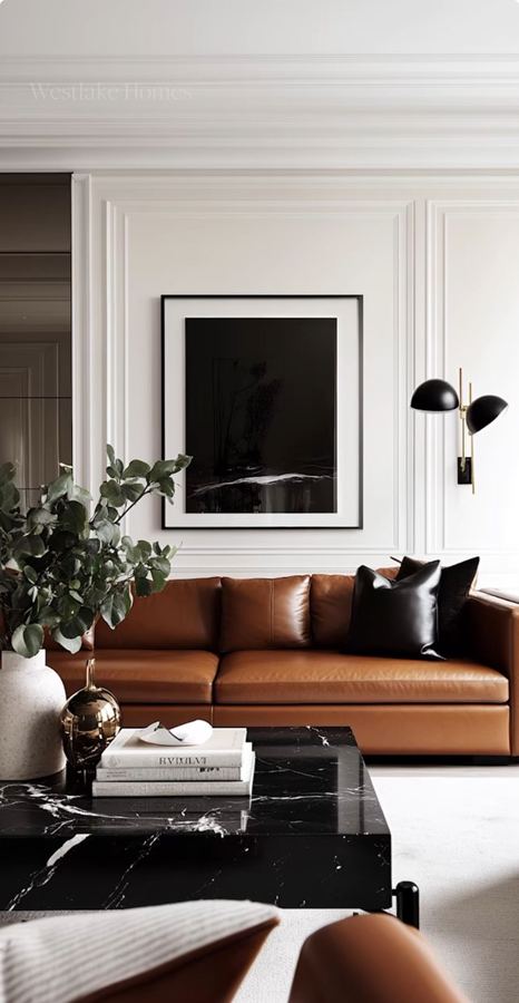 Paneled formal salon with cognac leather sofa, black marble veined coffee table, black framed art, black wall sconce